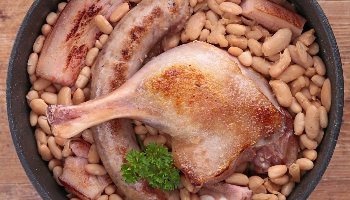 Cassoulet de Carcassonne gratiné servi dans une cassole en terre cuite