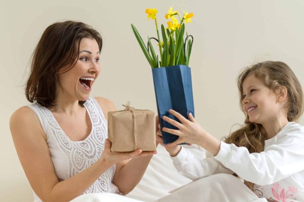 Une mère et sa fille échangent des cadeaux joyeusement.